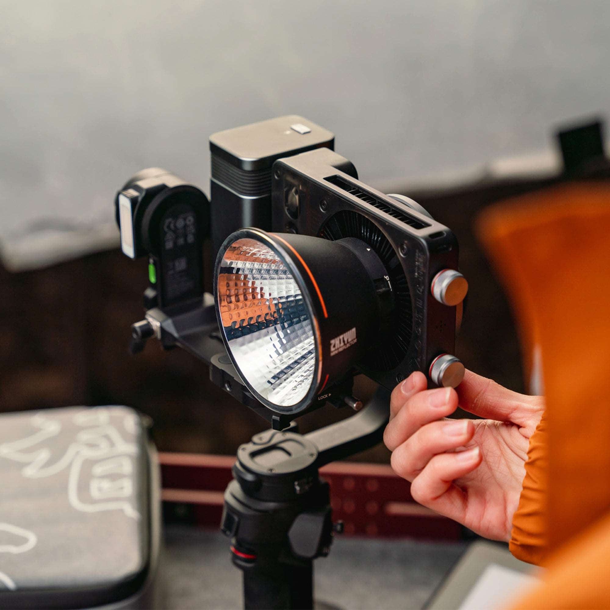 ZHIYUN MOLUS X100 portable COB light being adjusted on a camera rig
