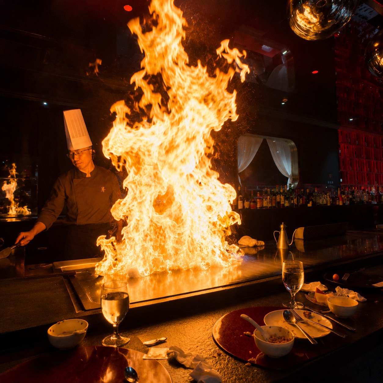 A teppanyaki chef cooking with a dramatic flame